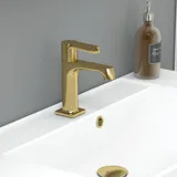 Stort badrum i gröna färger med tvättställsskåp, oval spegel med guldkant och vackra luckor med ram