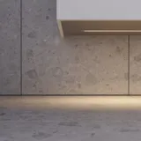 Stor badrumsinspiration med grå underskåp med integrerat handtag, snyggt sidomonterat handfat, fyrkantig spegel med rundade hörn, väggar i betonglook och råa material för en urban look