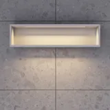 Stilfull badrumsinspiration med beige tvättställsskåp med innerskiva, överskåp, öppen hylla, ovalt spegel med belysning, matchande pendellampor, hylla under spegeln och vägghängd toalett. Väggar med ljusa, avlånga kakelplattor